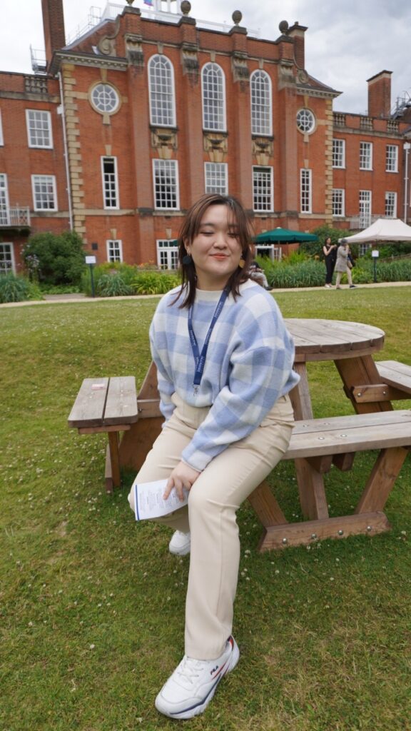 Medicine student Christine Yang sitting on a bench outside Lady Margaret Hall, Oxford